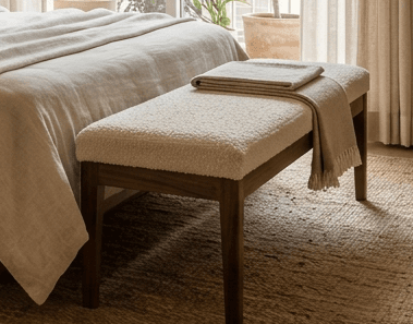 Setu Upholstered Bench with cream bouclé cushion and solid walnut legs with brass accents